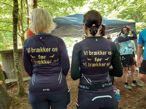To kvinder med teksten "Vi brækker os før vi trækker os" på trøjen.