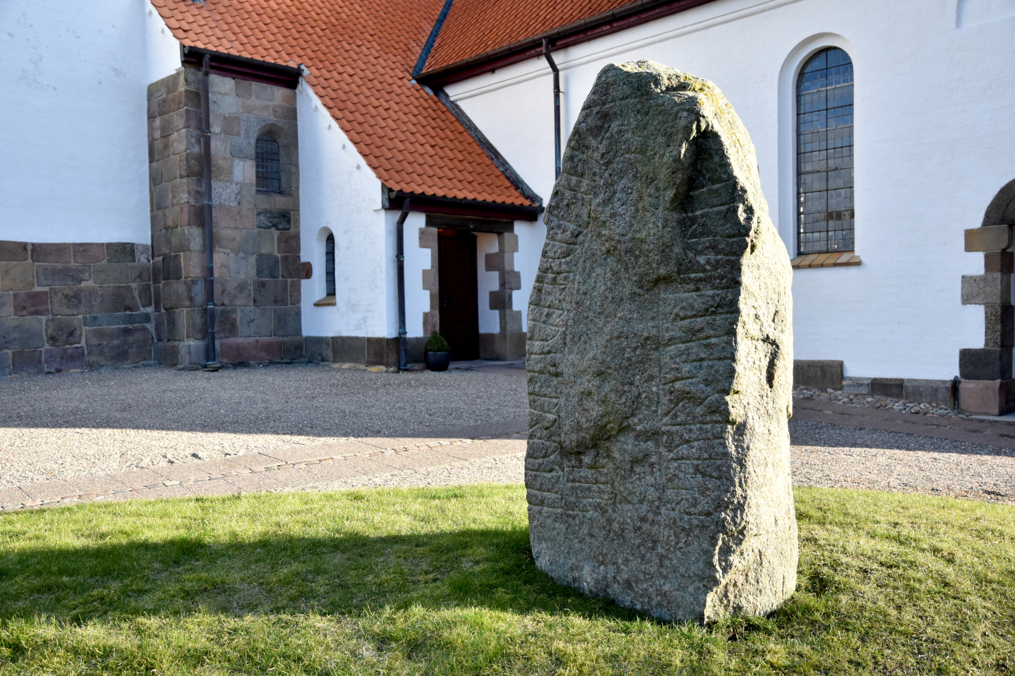Runesten foran en kirke.